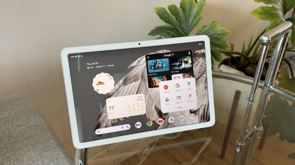 Google Pixel Tablet review with pixel tablet, sitting on glass top table in front of jaunty plant